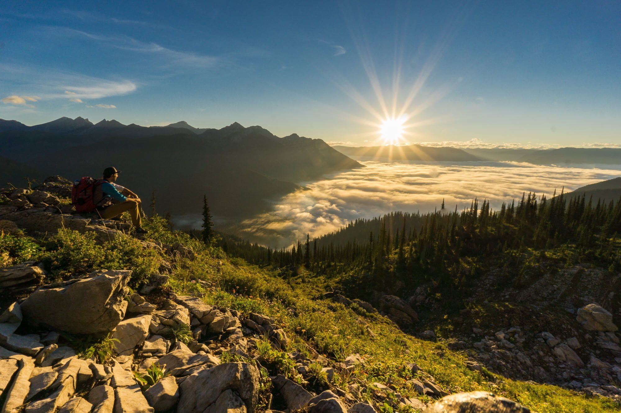 Hiker enjoying earlier morning sun along ridge top of Spineback Trail in Fernie BC